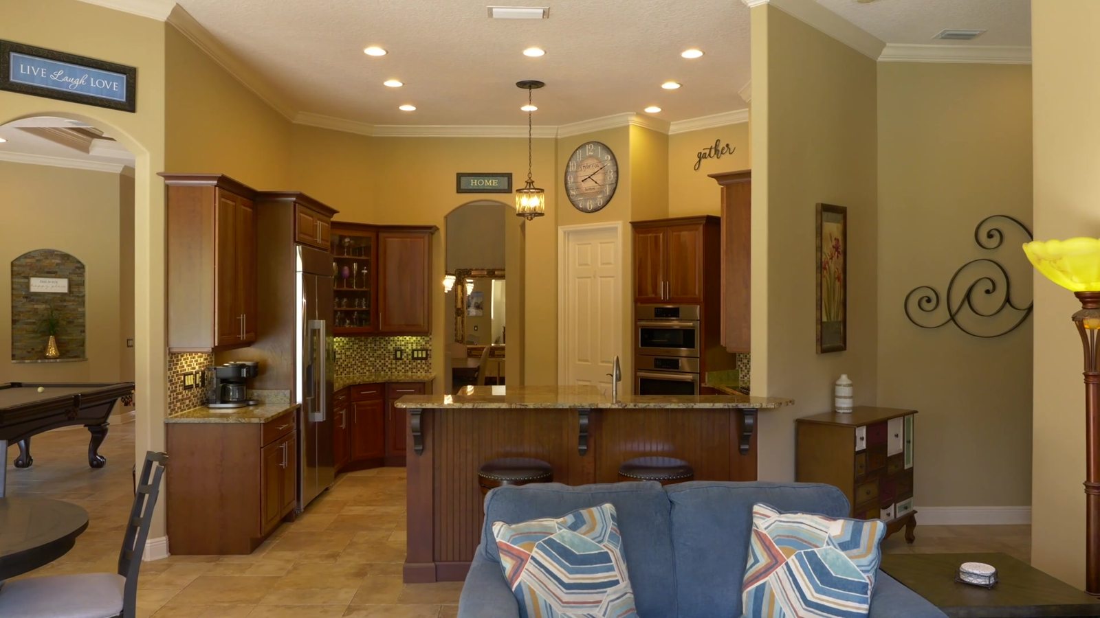 Chef's kitchen with wood cabinetry, granite counters and a large island in the Sanford home