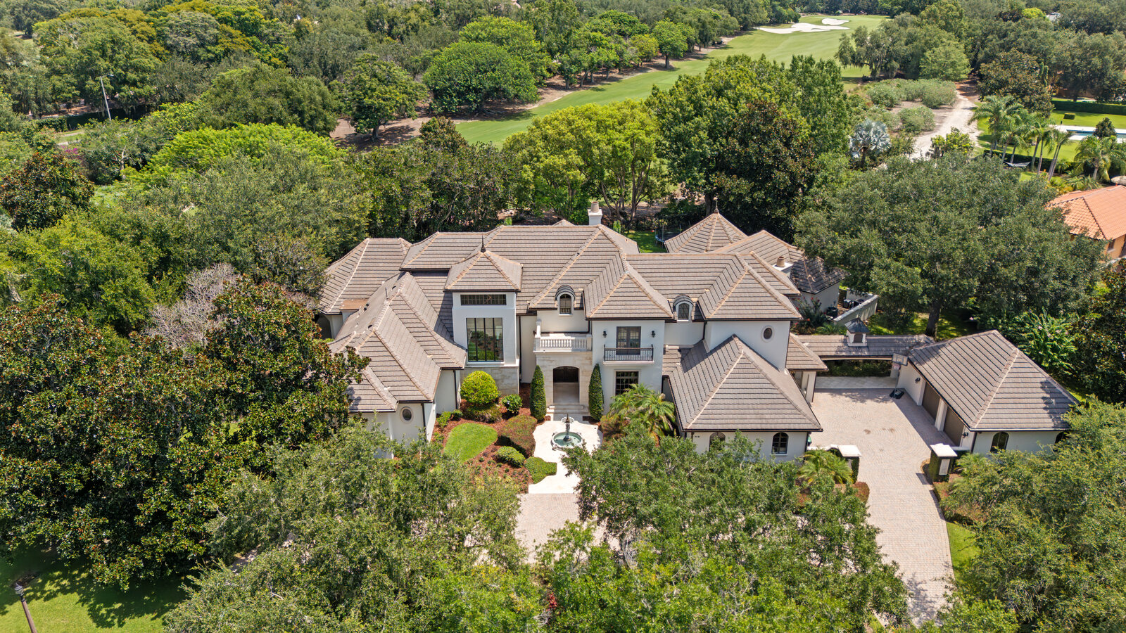 Aerial view of the Isleworth golf course estate at 9921 Lake Louise Drive surrounded by mature trees and the fairway
