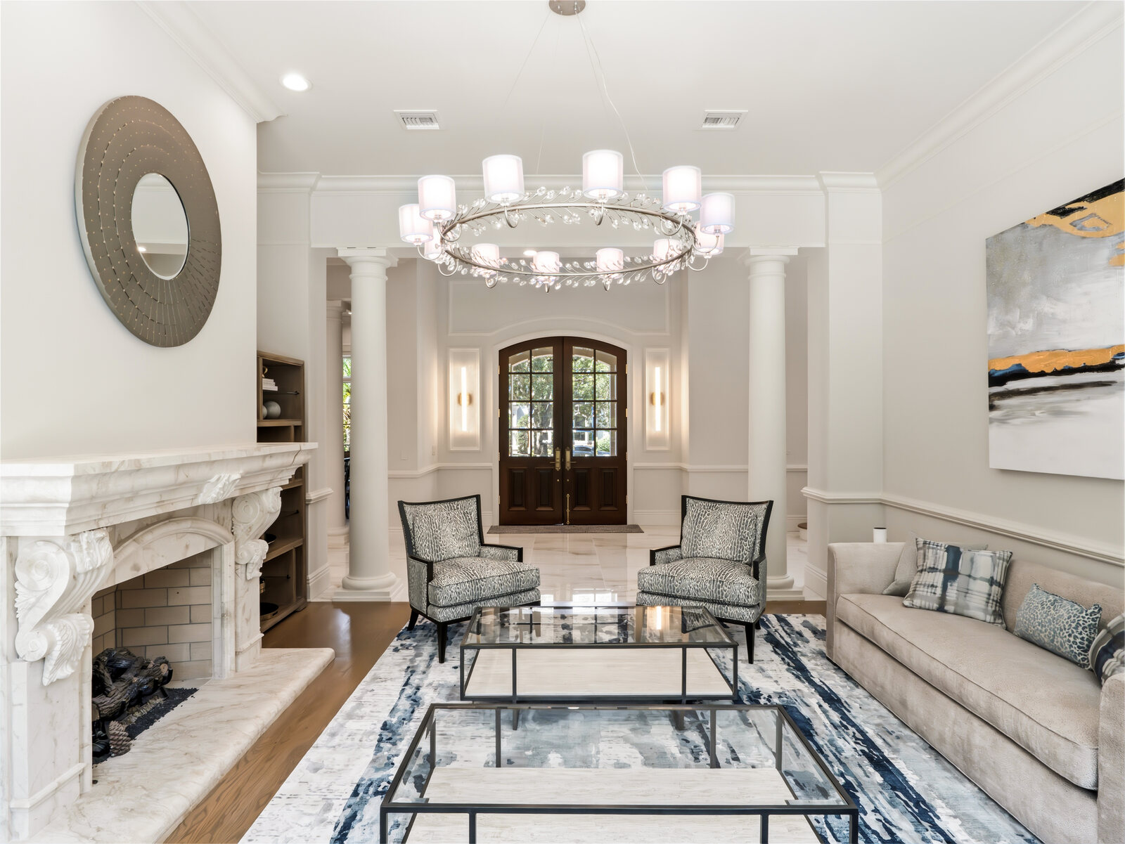 Formal living room with a bay window, stone fireplace and elegant seating in the renovated Isleworth home
