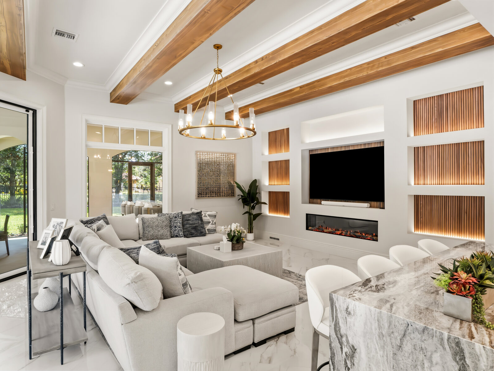 Family room with a linear fireplace, custom built-in cabinetry and a brass chandelier