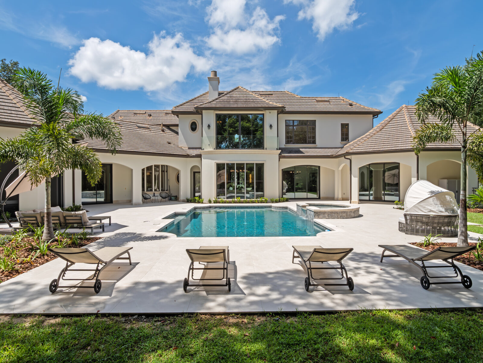 Resort-style backyard with a swimming pool, spa and lounge seating behind the Isleworth estate