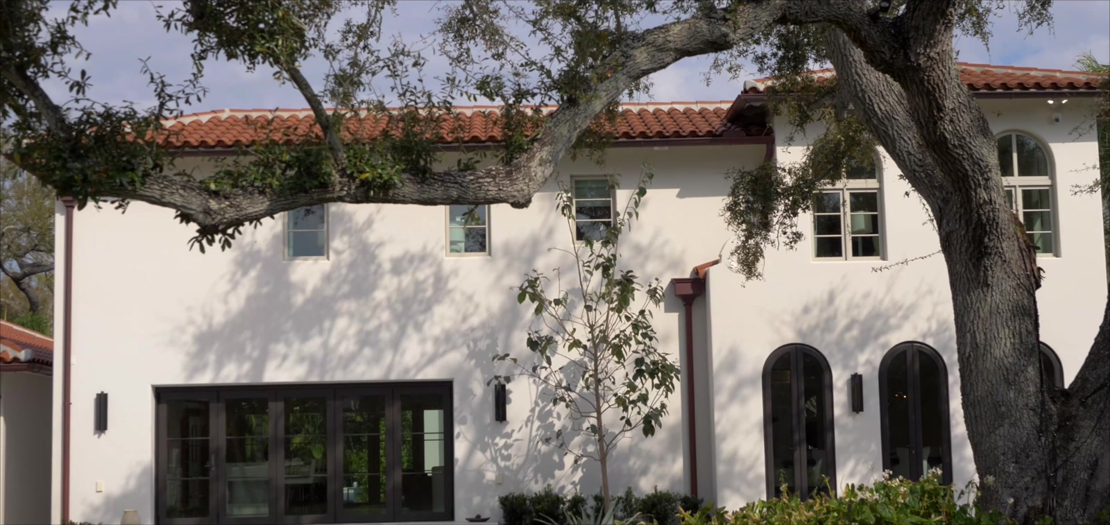Mediterranean Revival estate with a barrel-tile roof framed by a mature live oak on Snell Isle in St. Petersburg