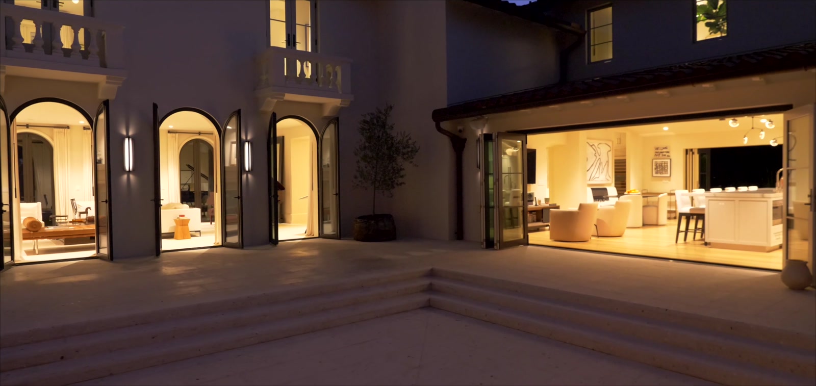 Lantern-lit interior courtyard opening to warmly lit living spaces at a Snell Isle estate at twilight